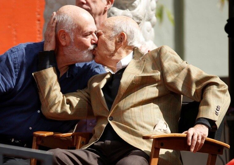 Toda essa intensidade costuma fazer bem. Vale para os beijos "unilaterais", quando a boca vai de encontro a outra superfície que não a de um lábio: o rosto, a mão, a testa, a nuca. E também quando os lábios se encontram e criam uma ligação profunda entre seres que se desejam ou se amam (na foto, pai e filho, Carl e Rob Reiner)