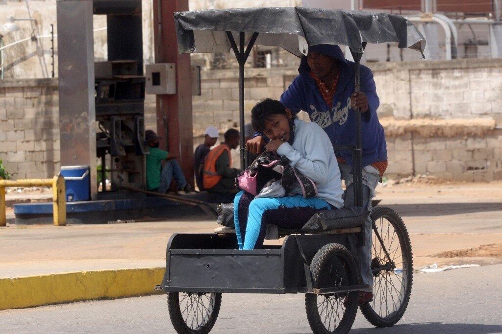 A girl rides a traditional tricycle taxi in Maracaibo, Zulia State, Venezuela, on July 29, 2021. Franklin relies on the wind to power his small sailboat. Manuel, a former bus driver, carries passengers in a "bicitaxi". Both manage to survive the chronic fuel shortages in Zulia, the region that saw the birth of Venezuela's oil industry.
Luis BRAVO / AFP