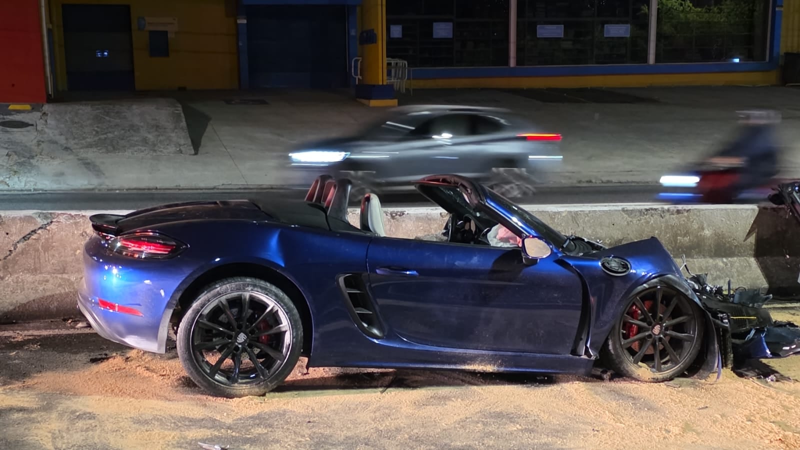 Carro de luxo azul destruído após acidente de trânsito