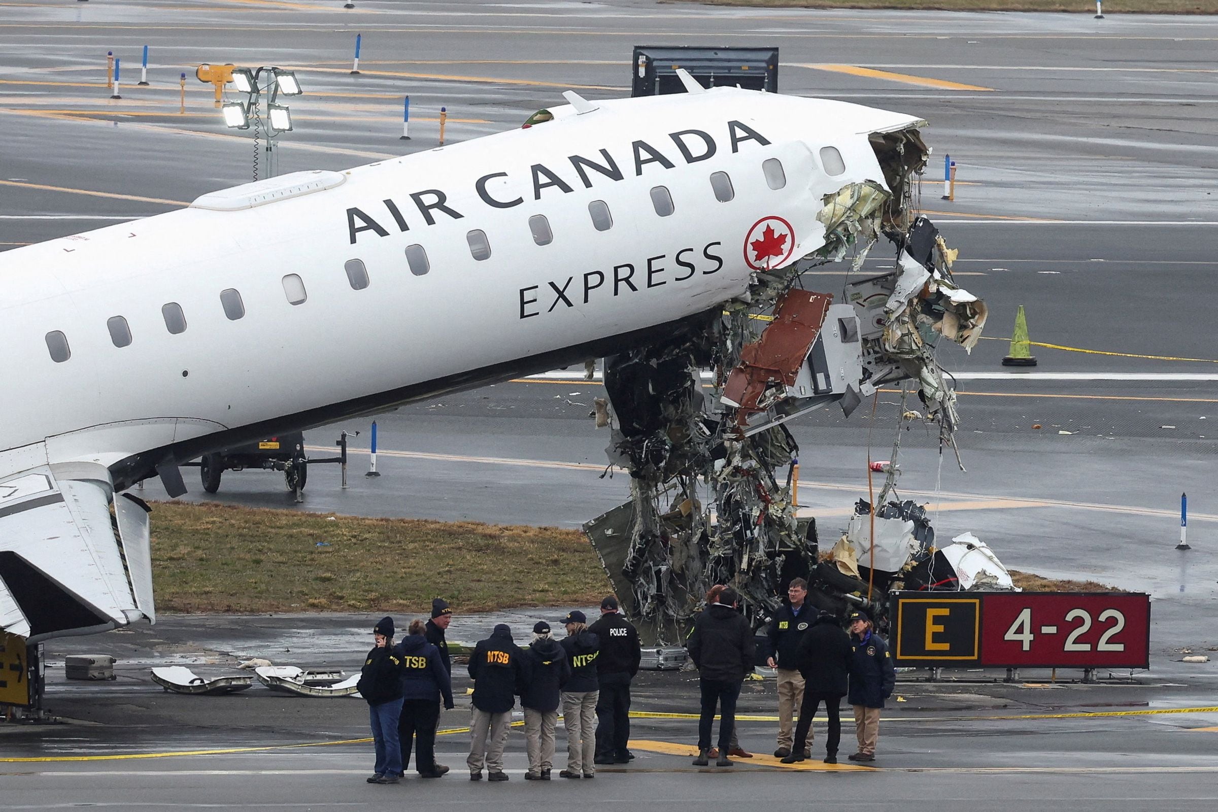 Investigadores do Conselho Nacional de Segurança nos Transportes examinam os destroços de um jato regional da Air Canada Express no Aeroporto LaGuardia de Nova York, na segunda-feira.