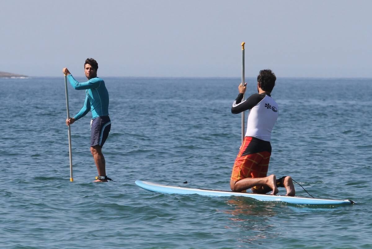 Bruno Gagliasso e Ricardo Pereira praticam stand up paddle na praia da Barra da Tijuca, no Rio
