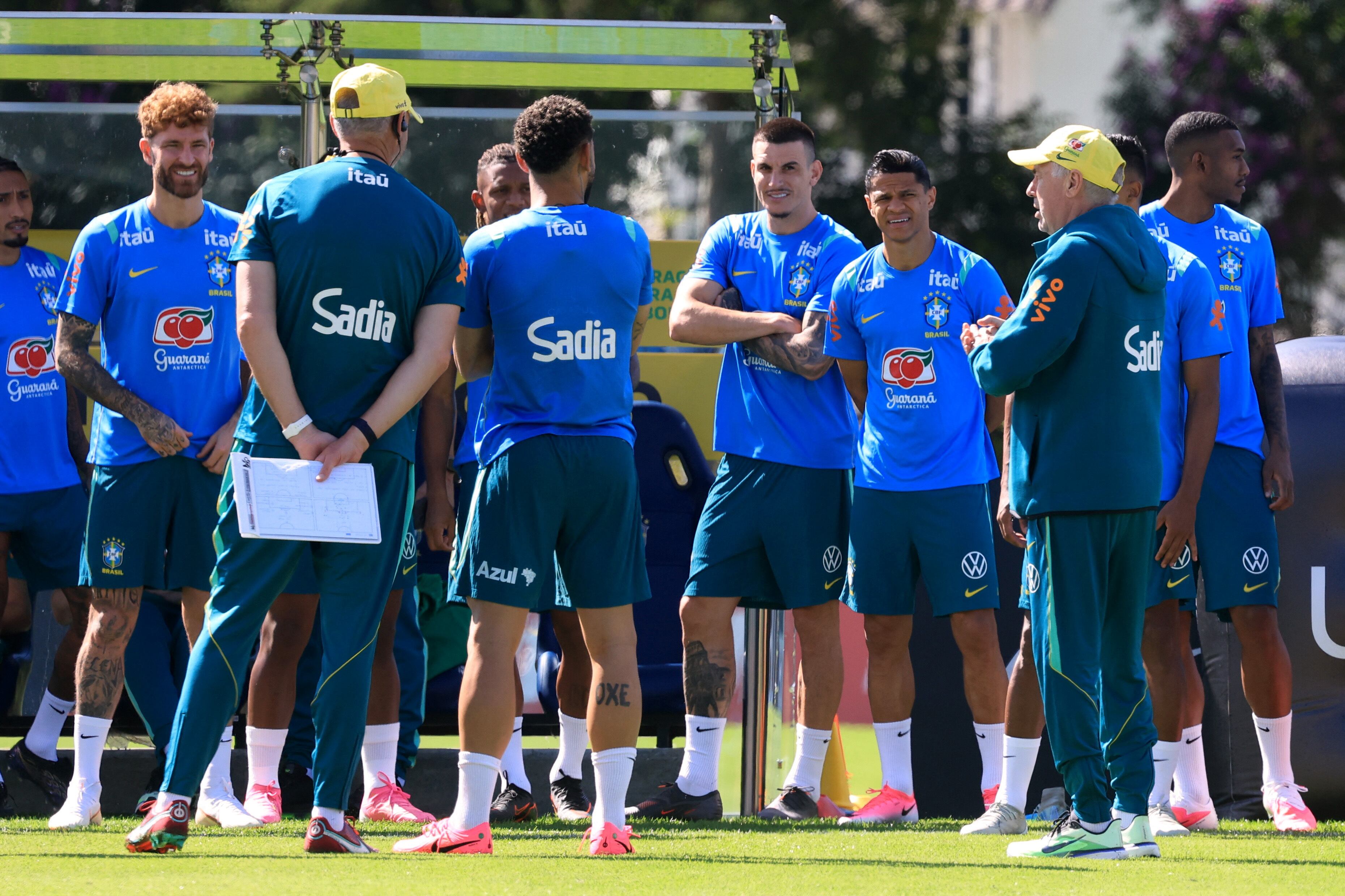 Técnico Carlo Ancelotti fala com jogadores da seleção brasielira vestidos com uniforme de treino azul