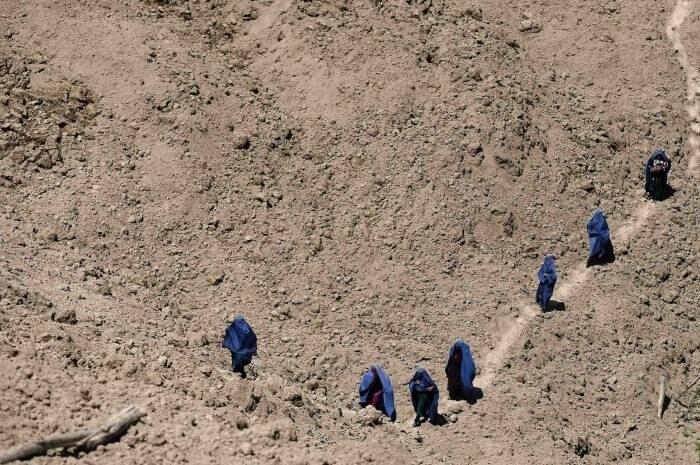 Mulheres afegãs chegam na região do deslizamento de terra no Afeganistão após o corpo de uma mulher ter
sido encontrado no local 