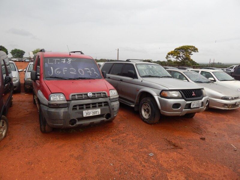 O Fiat Doblò Adventure (vermelho) ano 2004, o lote 78, tem valor inicial definido em R$ 3.000,00. O Pajero, ao lado, corresponde ao lote 77 e tem lance mínimo fixado em R$ 3.000,00