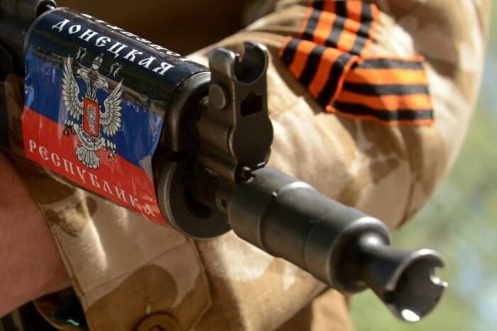 Um homem segura uma arma
enfeitada com a bandeira da auto-proclamada República Popular de Donetsk e
guarda um prédio tomado por manifestantes pró-russos em Slaviansk, na Ucrânia