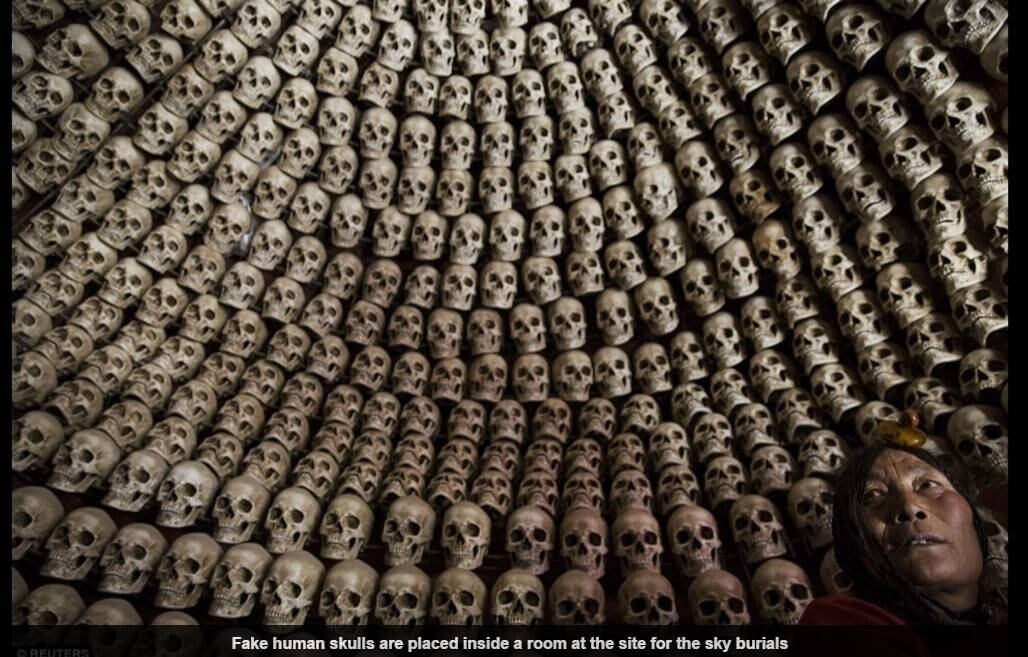 Na imagem, crânios humanos falsos são colocados dentro de uma sala no local onde ocorrem os "funerais aéreos"