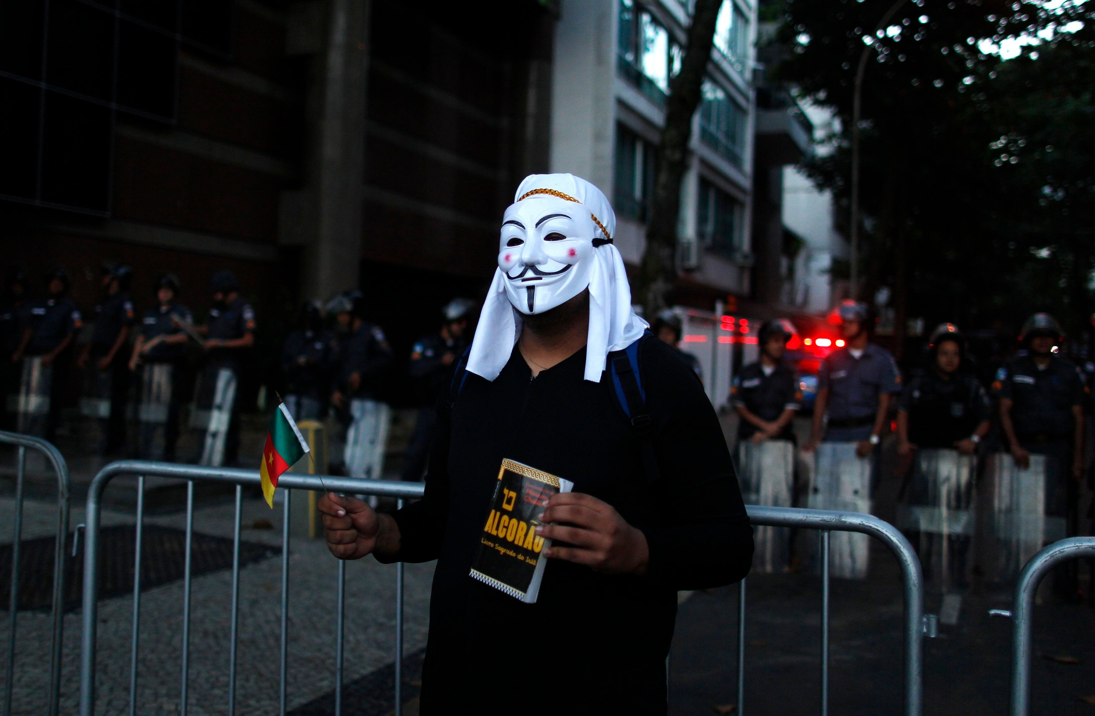 Manifestante protesta nas proximidades da casa de Sérgio Cabral com uma máscara e um Alcorão, livro sagrado dos muçulmanos