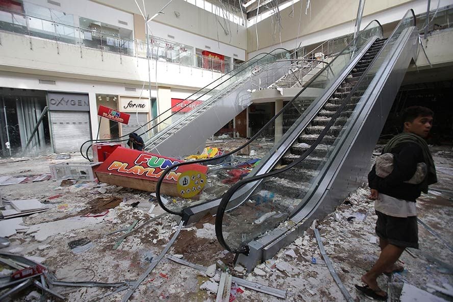 Acima, shopping que foi inundado durante o tufão e, de acordo com testemunhas, foi saqueado em seguida