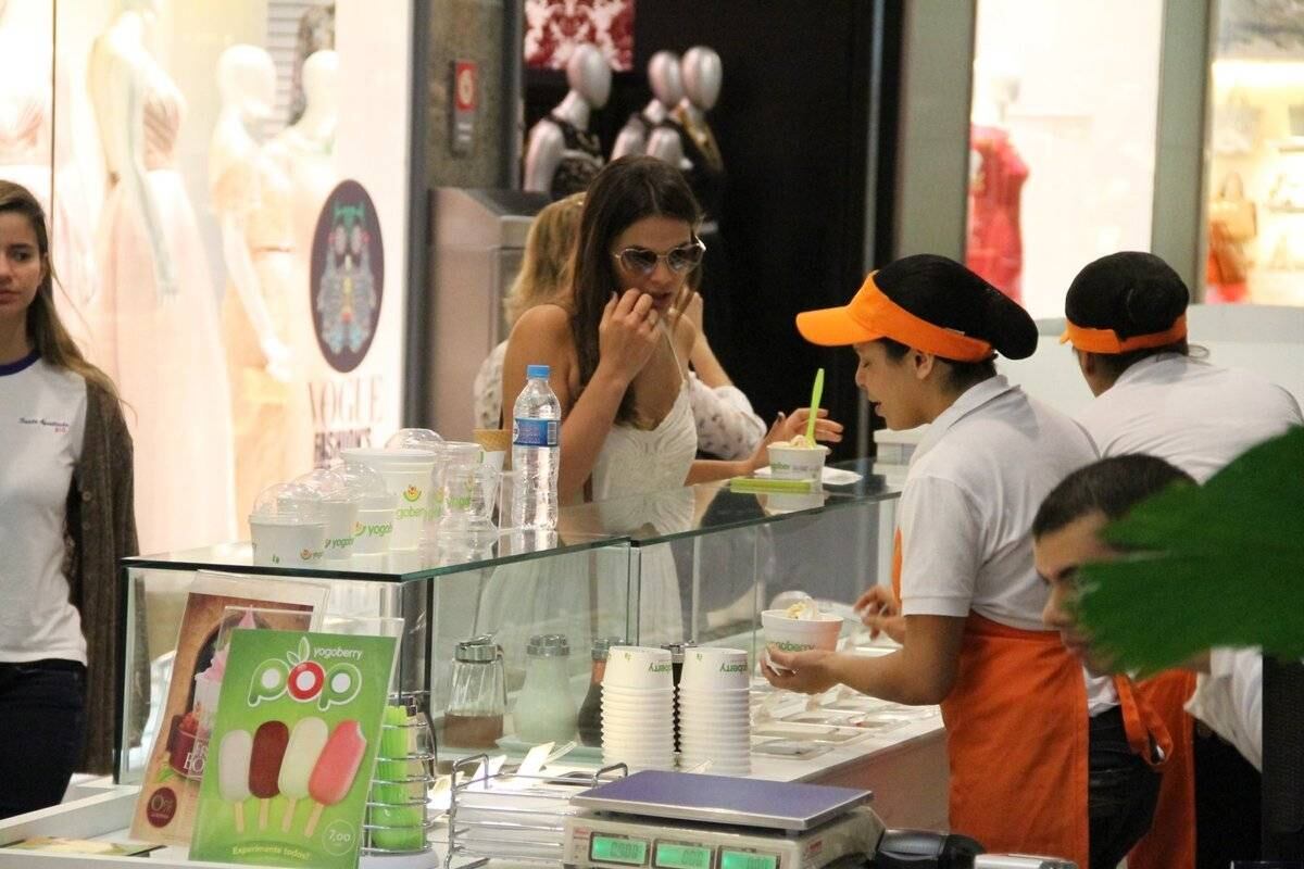 Durante o passeio, ela parou para tomar frozen iogurte e ficou indecisa sobre o que colocar nele