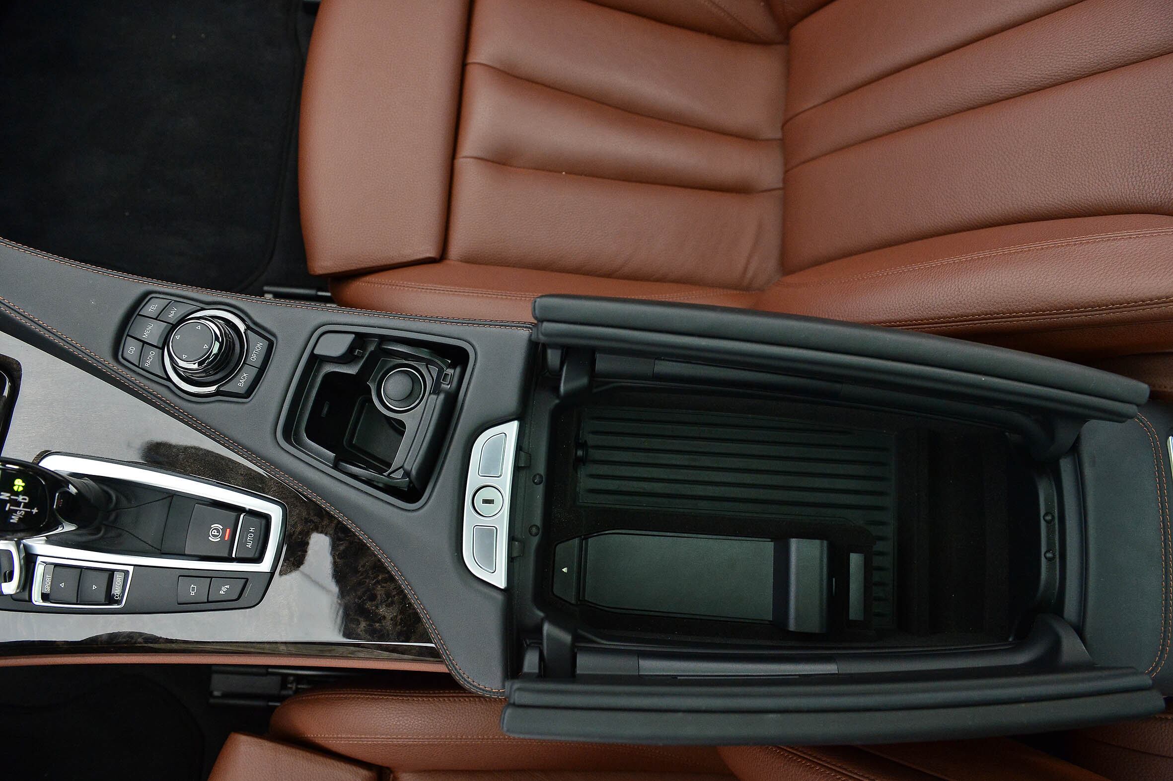 Elevado devido ao cardã que atravessa a cabine, o console central conta com um grande compartimento central