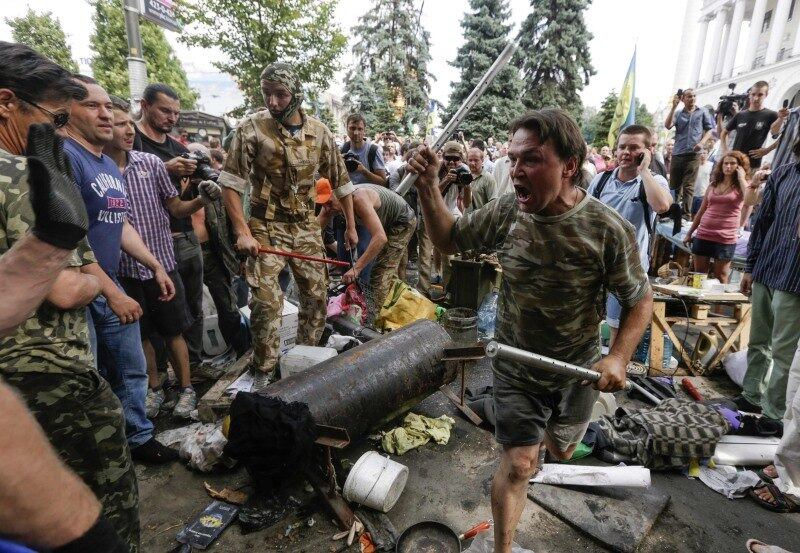 Manifestantes tentam impedir
que garis e voluntários retirem suas barracas e barricadas da Praça da Independência
em Kiev, na Ucrânia