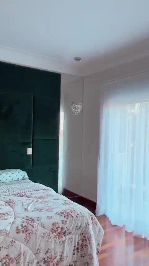 Já no quarto da doutora, o destaque fica para uma charmosa parede verde de veludo, ladeada por espelhos verticais e mais duas luminárias de cristal. A mansão possui cinco suítes