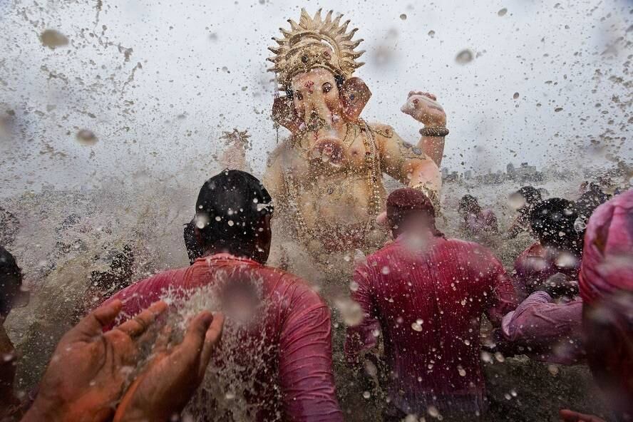 Devotos hindus jogam água em uma grande estátua do deus hindu, Ganesha, antes de mergulharem, em um ritual. Nesta segunda-feira (8), os hindus comemoram o último dia do festival Chaturthi, na Índia