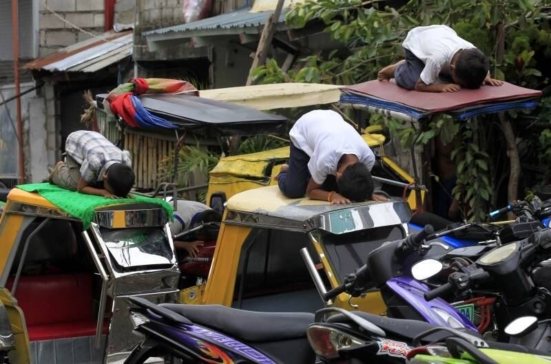 Jovens muçulmanos rezam em
cima de taxis em frente à mesquita de Al-Satie, em Manila, nas Filipinas