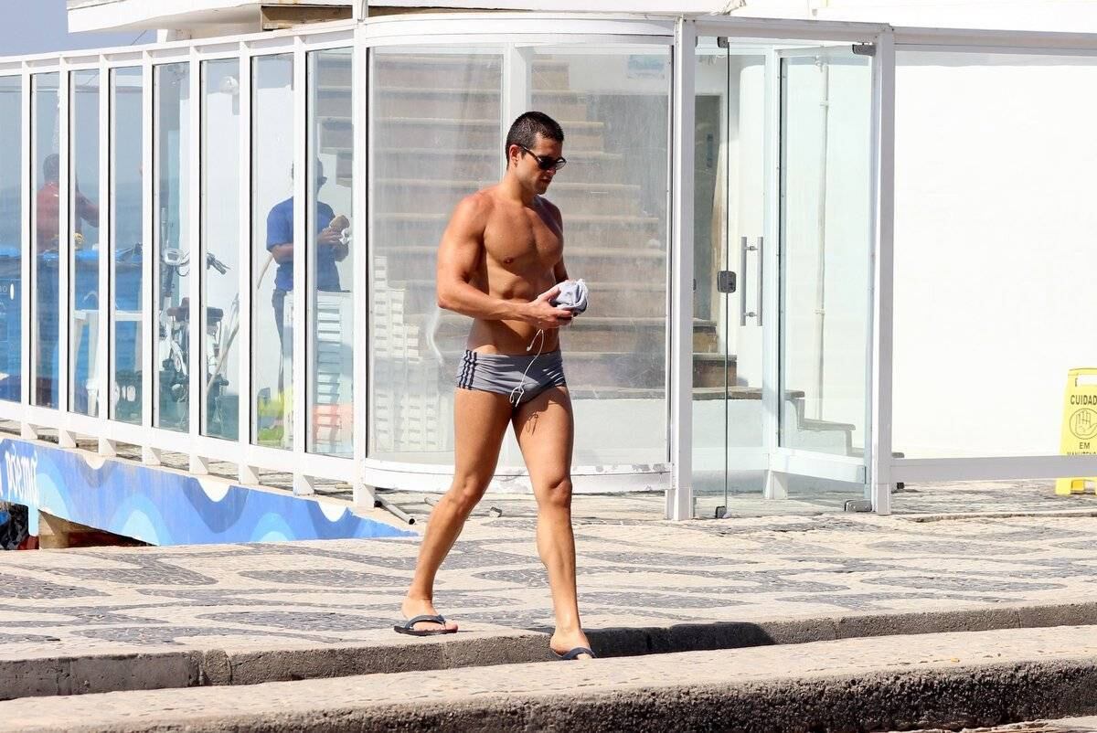 Com a camiseta na mão e chinelos, ele atravessou a rua 