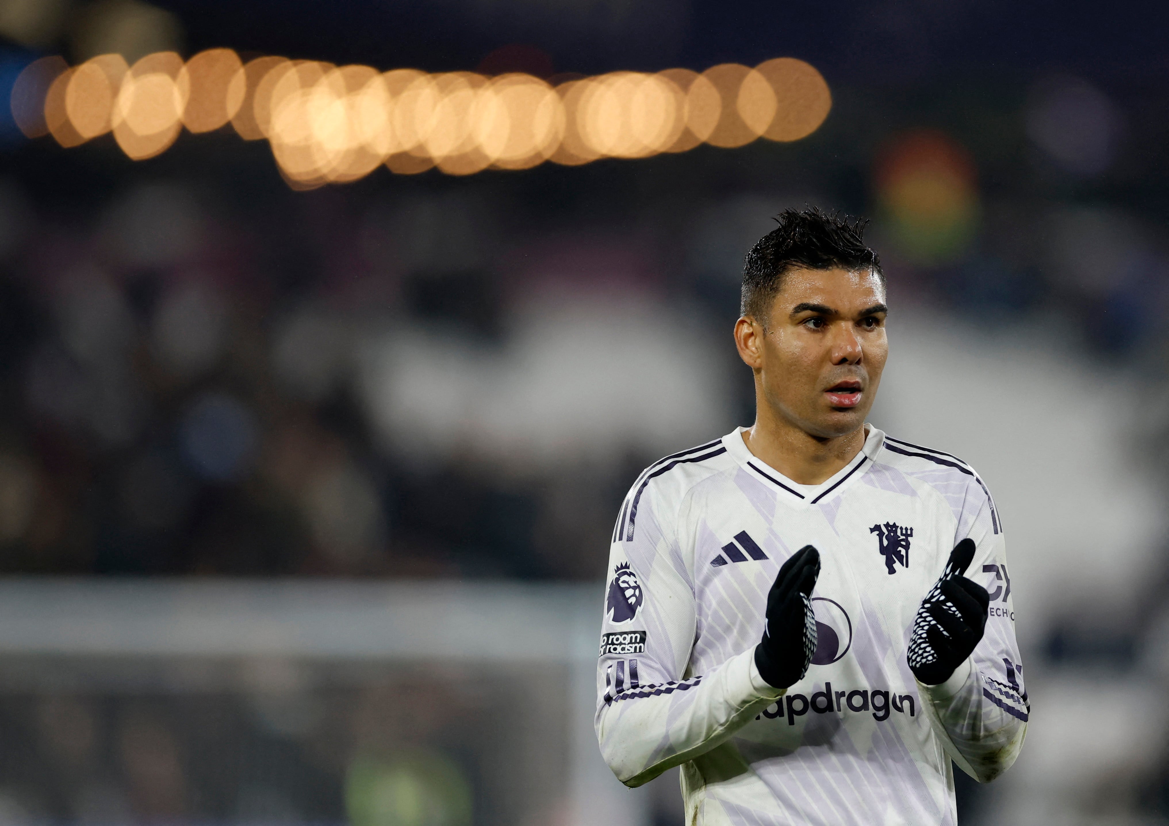 Casemiro, com a camisa do Manchester United, olha para o campo e faz um movimento de aplaudir