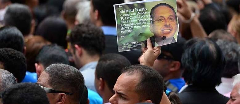 Homem segura cartaz com imagem de Campos durante seu velório, em Recife