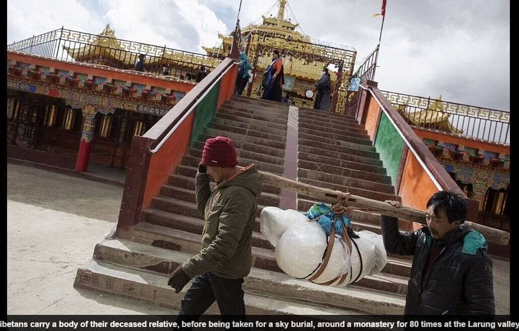Na foto, dois tibetanos carregam o corpo de um parente falecido, que será oferecido às aves em um "funeral aéreo" 