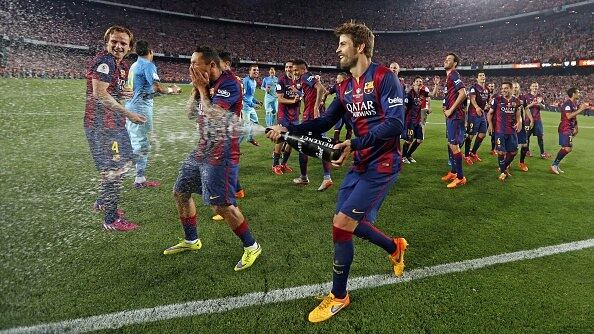 Jogando champanhe em todo mundo, o zagueiro Piqué era um dos mais animados da festa