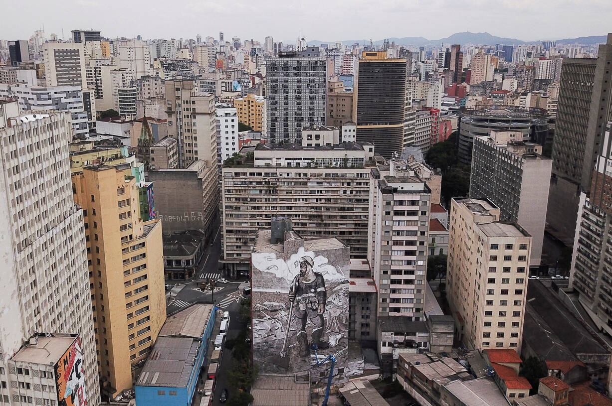 An aerial view shows brazilian artist and activist Mundano works on the mural 'The Forest Brigade' using paint made with ashes collected and brought from fires in Amazon, Pantanal and other biomes, in Sao Paulo, Brazil October 14, 2021. Picture taken with a drone. REUTERS/Amanda Perobelli