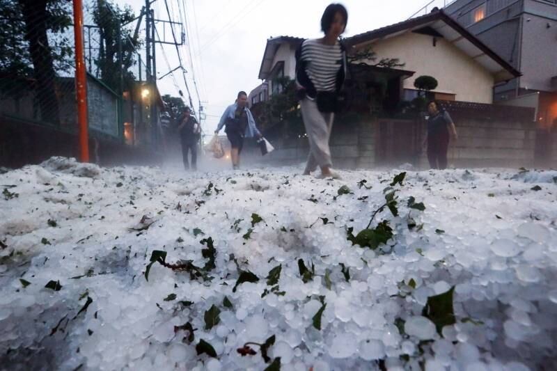 Pedrestres caminham por
rua coberta de granizo em Tóquio, no Japão