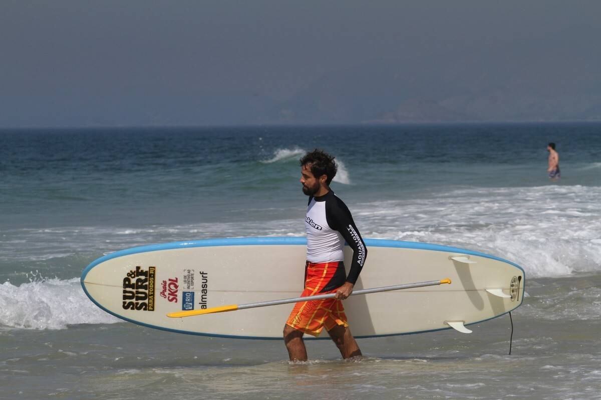 Bruno Gagliasso e Ricardo Pereira praticam stand up paddle na praia da Barra da Tijuca, no Rio
