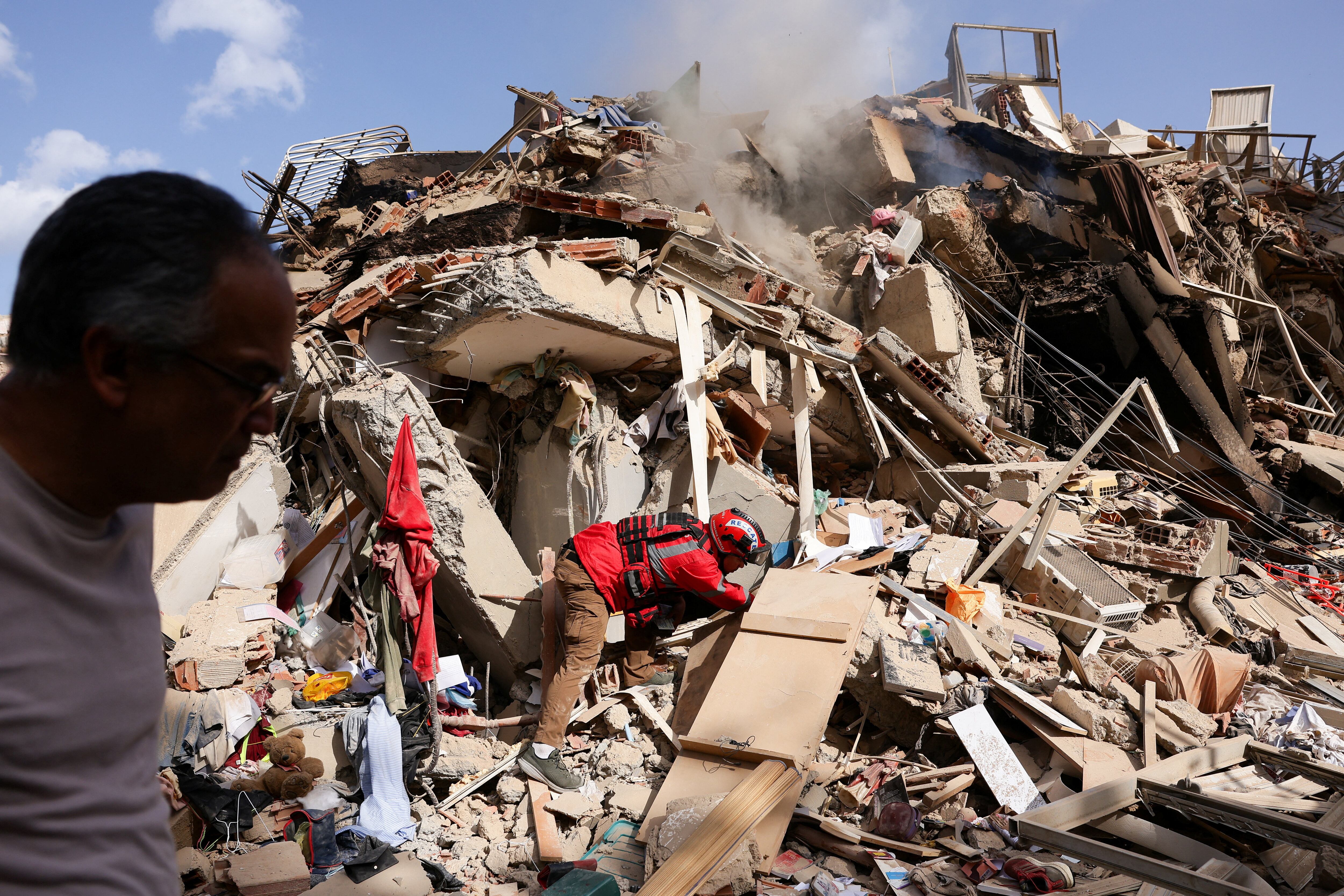 Juan Carlos Gomez, bombeiro de Caracas, procura sua irmã, Katiuska Hernandez, e seu sobrinho, Brett Roude, em meio aos escombros de um prédio, após os terremotos que atingiram o país, em La Guaira, Venezuela