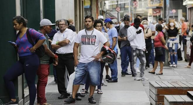 Fila de pessoas em frente a uma agência bancária na região central de São Paulo