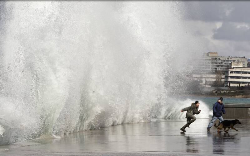 Crianças fogem de onda em Sevastopol, na Ucrânia, em março de 2012