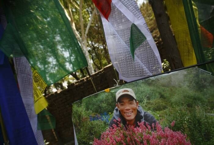 Um retrato de Ankaji Sherpa, que morreu na avalanche, é visto durante a cerimônia de cremação das vítimas

