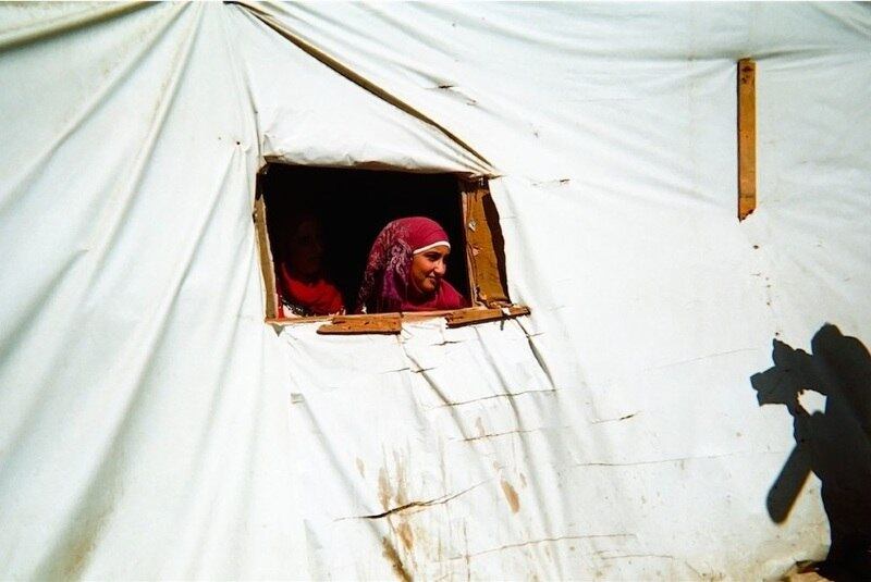 Esta mulher síria olha da janela de seu abrigo em um assentamento, no Vale do Bekaa. Ela foi fotografada por Abdel,de 11 anos