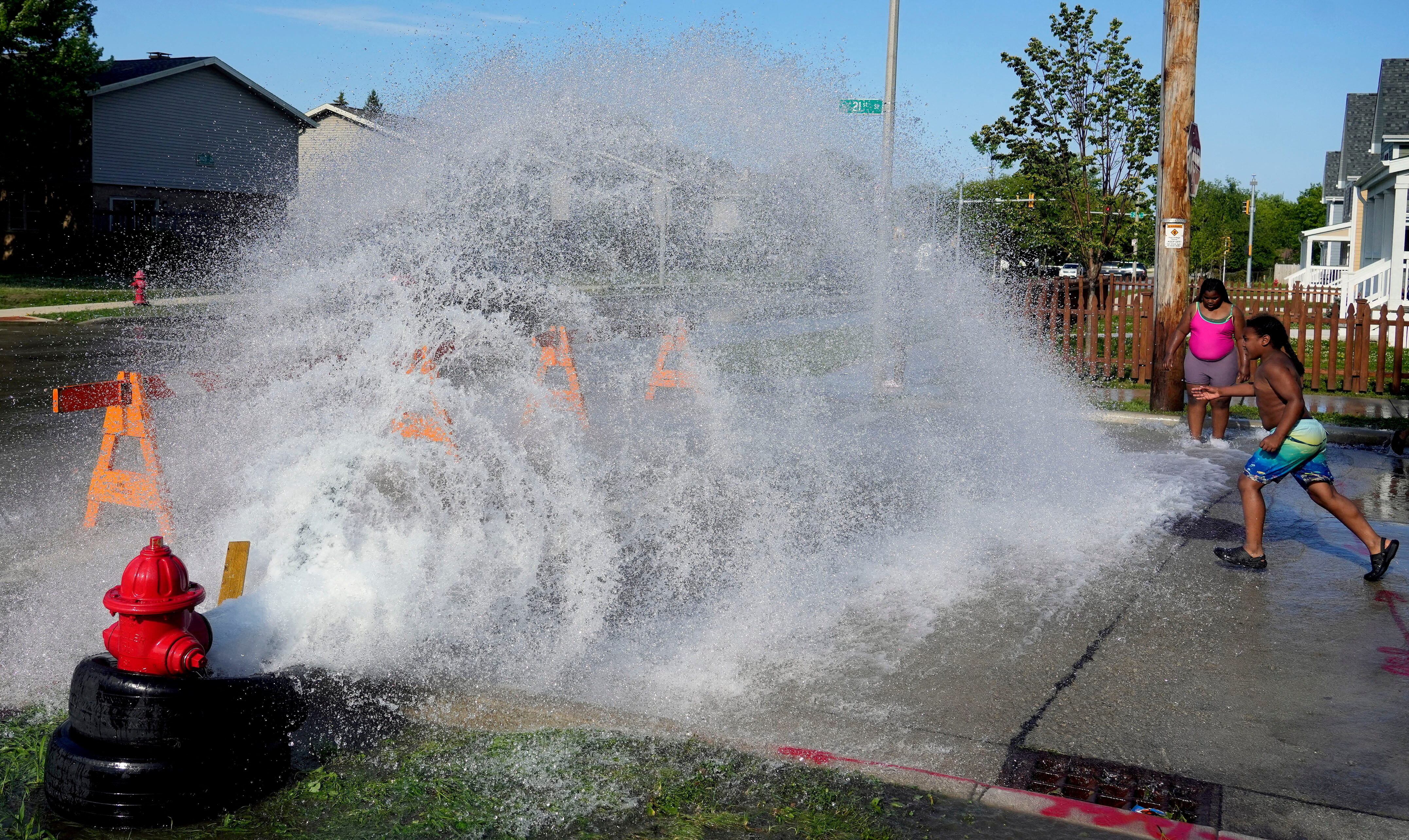 Abertura não autorizada de um hidrante proporciona um alívio temporário do calor extremo para crianças em Milwaukee