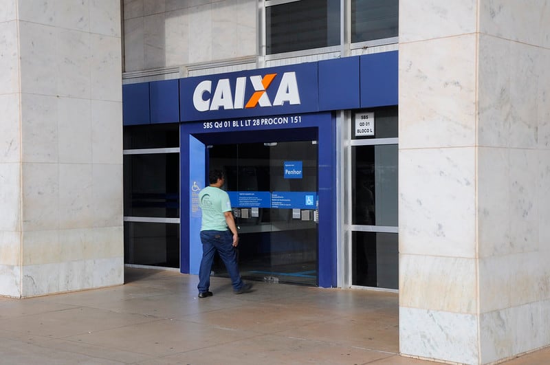 Fachada da Caixa Econômica Federal com um cliente entrando na unidade