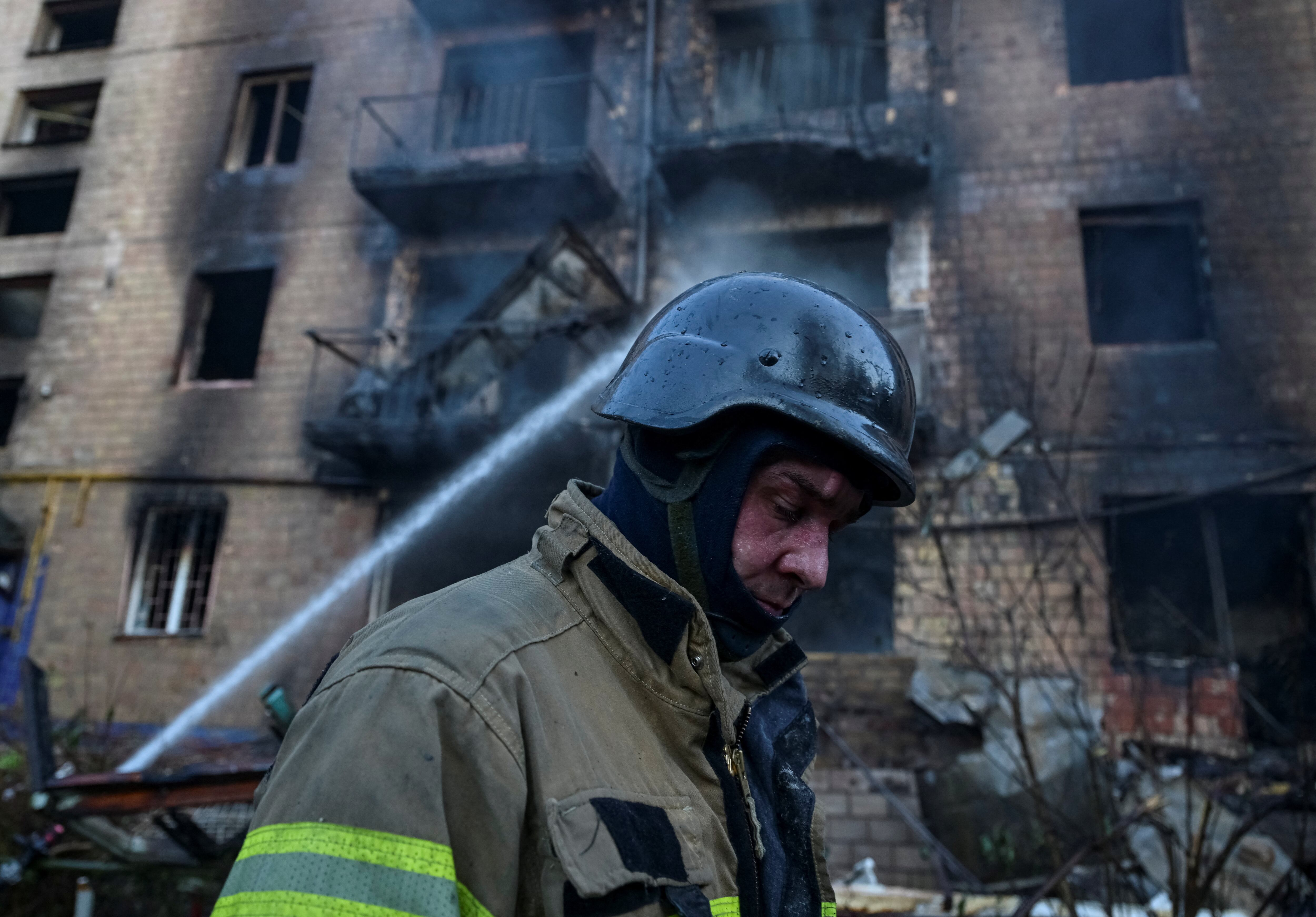 Um bombeiro caminha perto de um prédio de apartamentos danificado durante um ataque russo com mísseis e drones, em meio ao ataque da Rússia à Ucrânia, em Kiev, Ucrânia