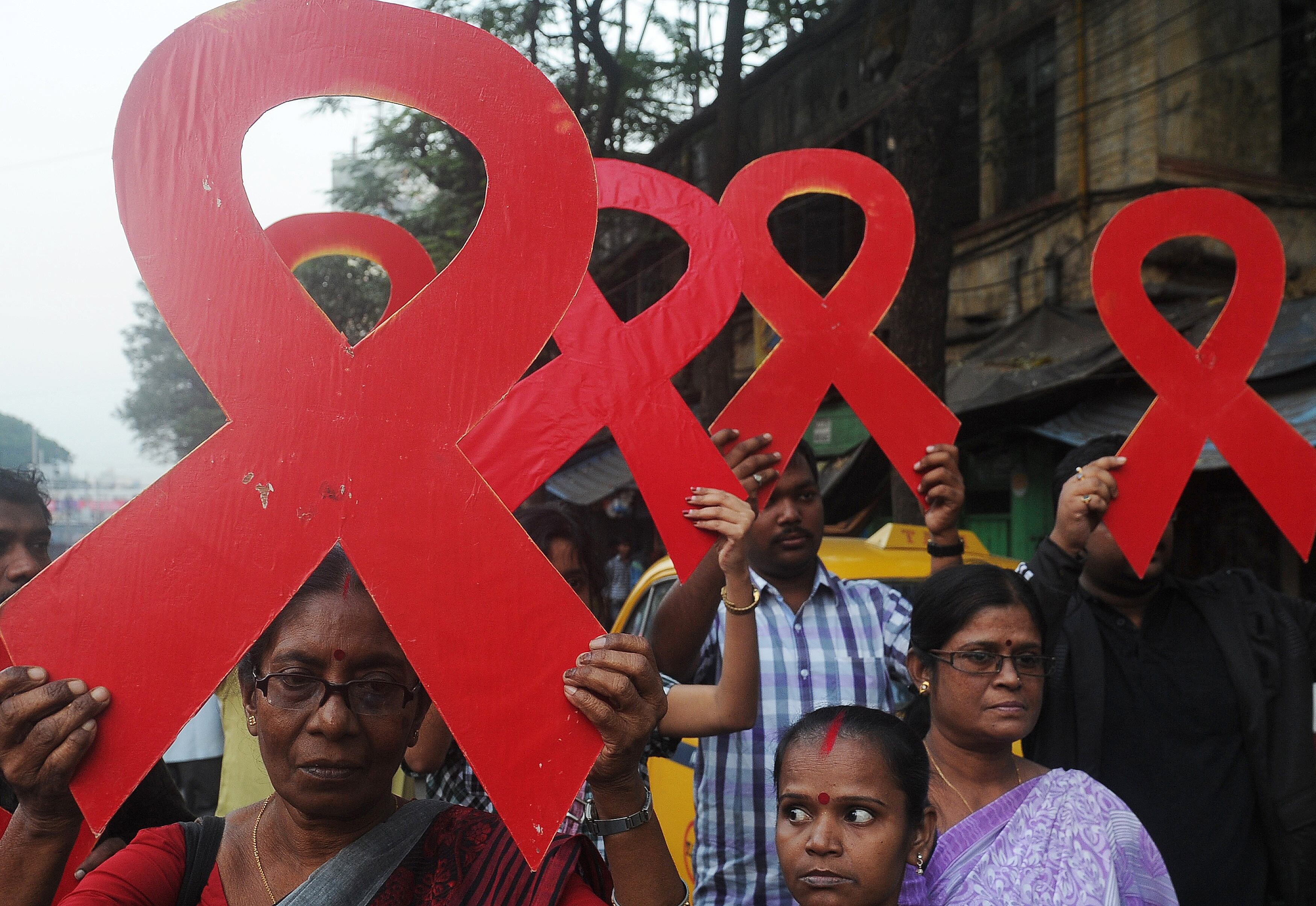

Voluntários indianos e membros de organização social seguram o símbolo da campanha da luta contra a Aids durante
comício, em Calcutá

