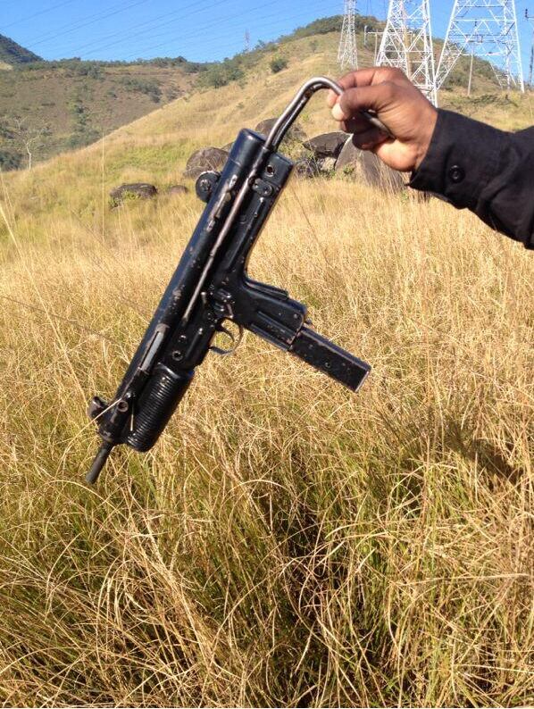 Um agente do Bope mostra uma submetralhadora apreendida na megaoperação no Complexo do Lins de Vasconcelos. A arma estava com um homem que foi morto no confronto entre policiais e traficantes