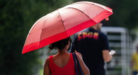 Mulher se protege do calor com guarda-chuva, na Barra Funda, zona oeste de São Paulo
