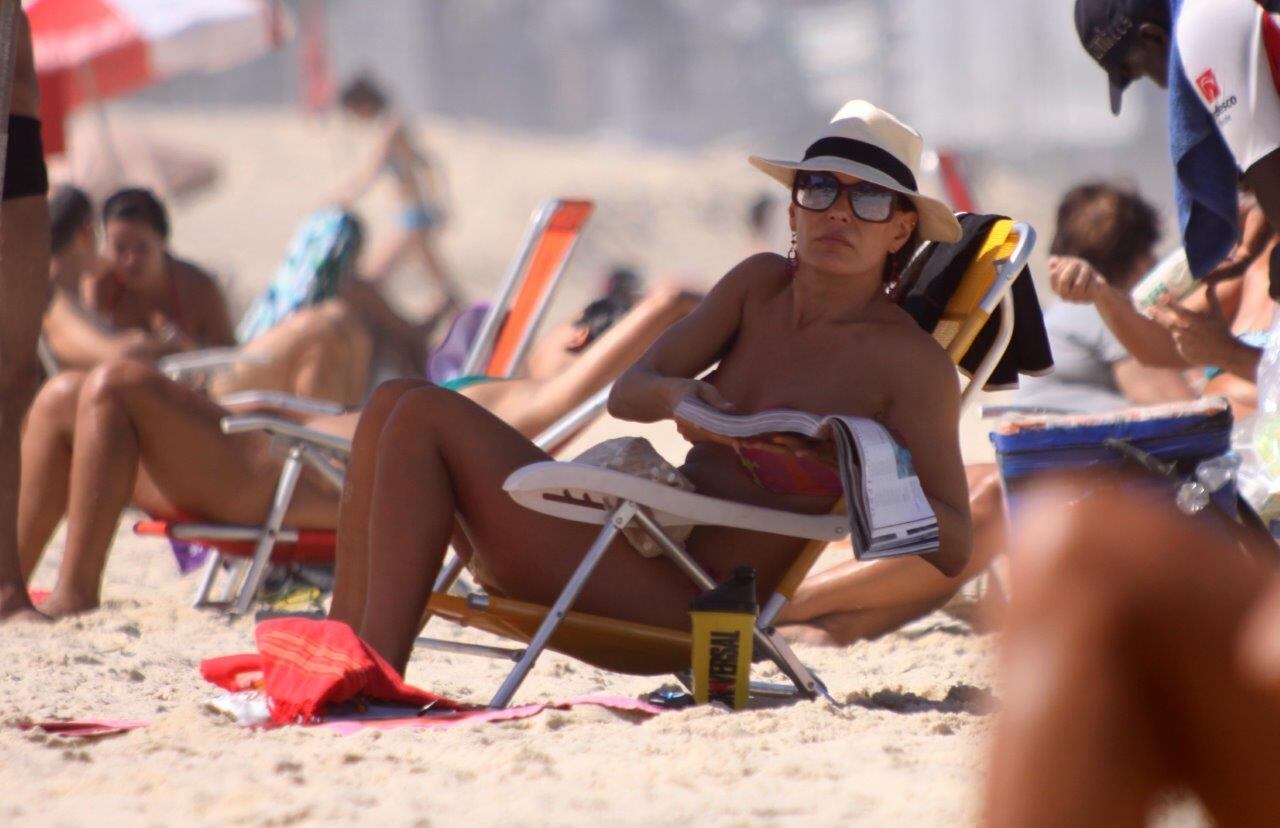 Carolina Ferraz foi flagrada na praia do Leblon com o namorado Marcelo Marins