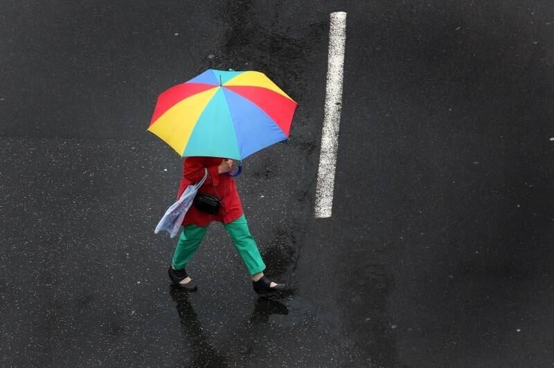Mulher com guarda-chuva caminha
pelas ruas de Dusseldorf, na Alemanha