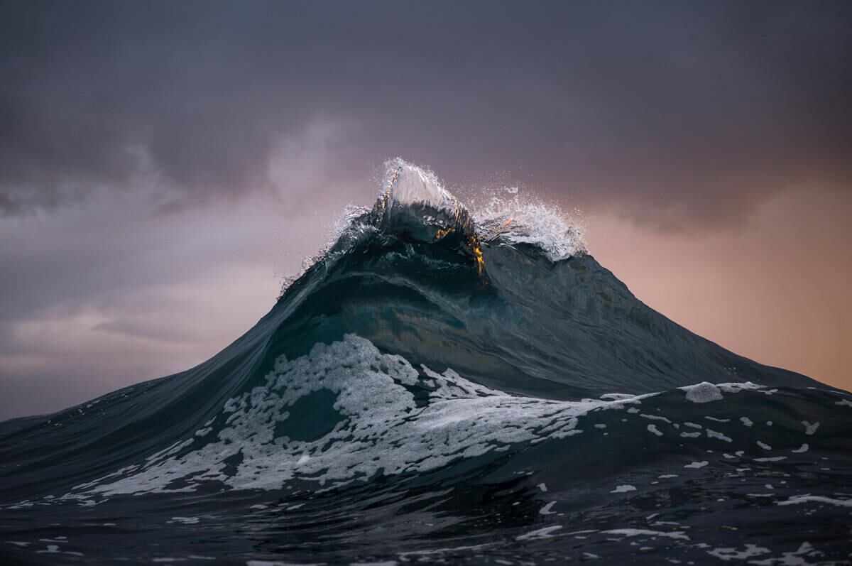 A foto ganhadora desta mesma categoria foi registrada por Ray Collins, que mostra duas ondas se encontrando e formando uma imagem parecida com uma montanha com pico de gelo