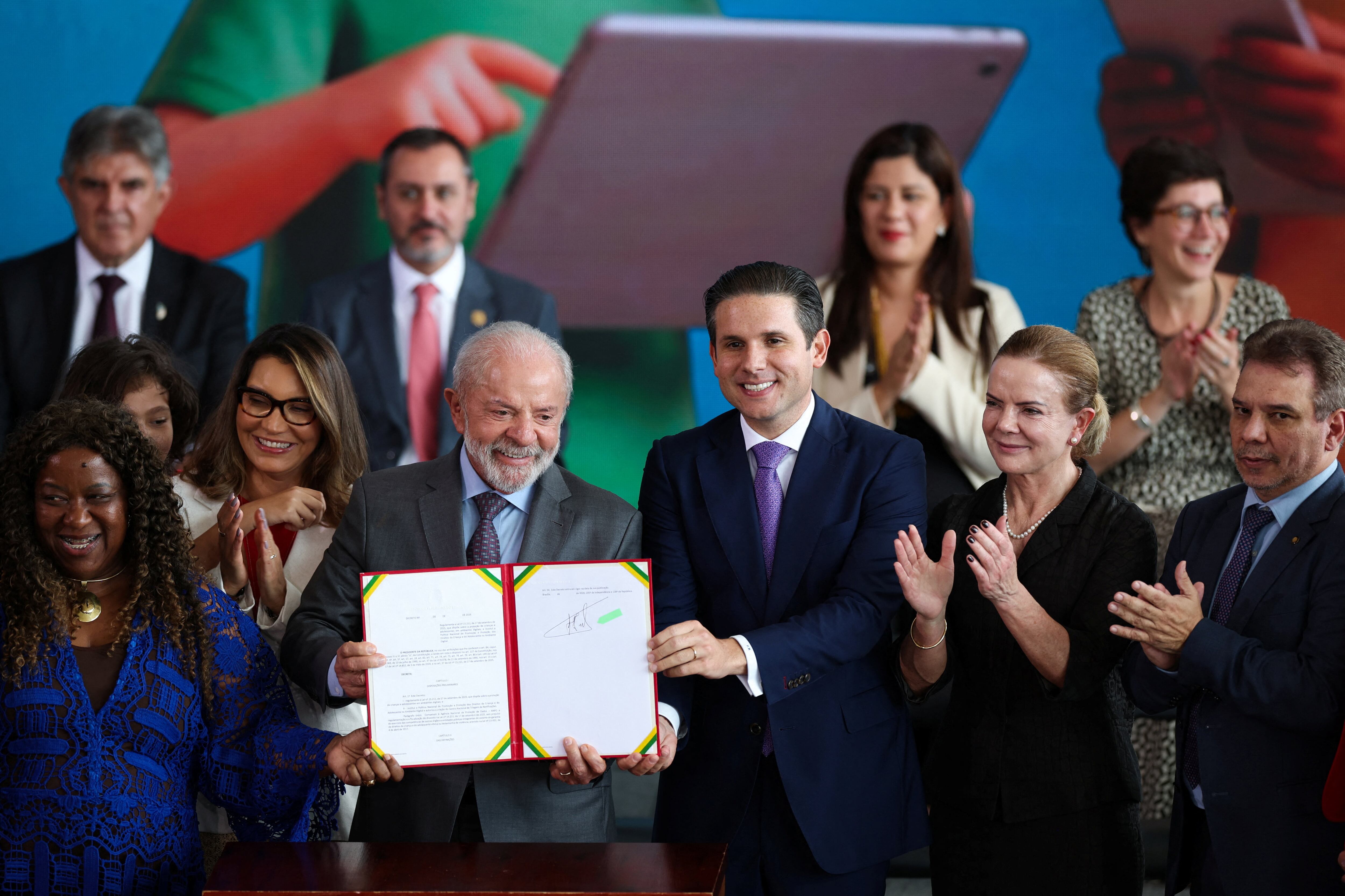 Brazil's President Luiz Inacio Lula da Silva, Brazil's Minister of Justice Wellington Cesar Lima and President of the Chamber of Deputies Hugo Motta attend a signing ceremony for a decree to protect children and adolescents in digital environments, at the Planalto Palace in Brasilia, Brazil, March 18, 2026. REUTERS/Adriano Machado