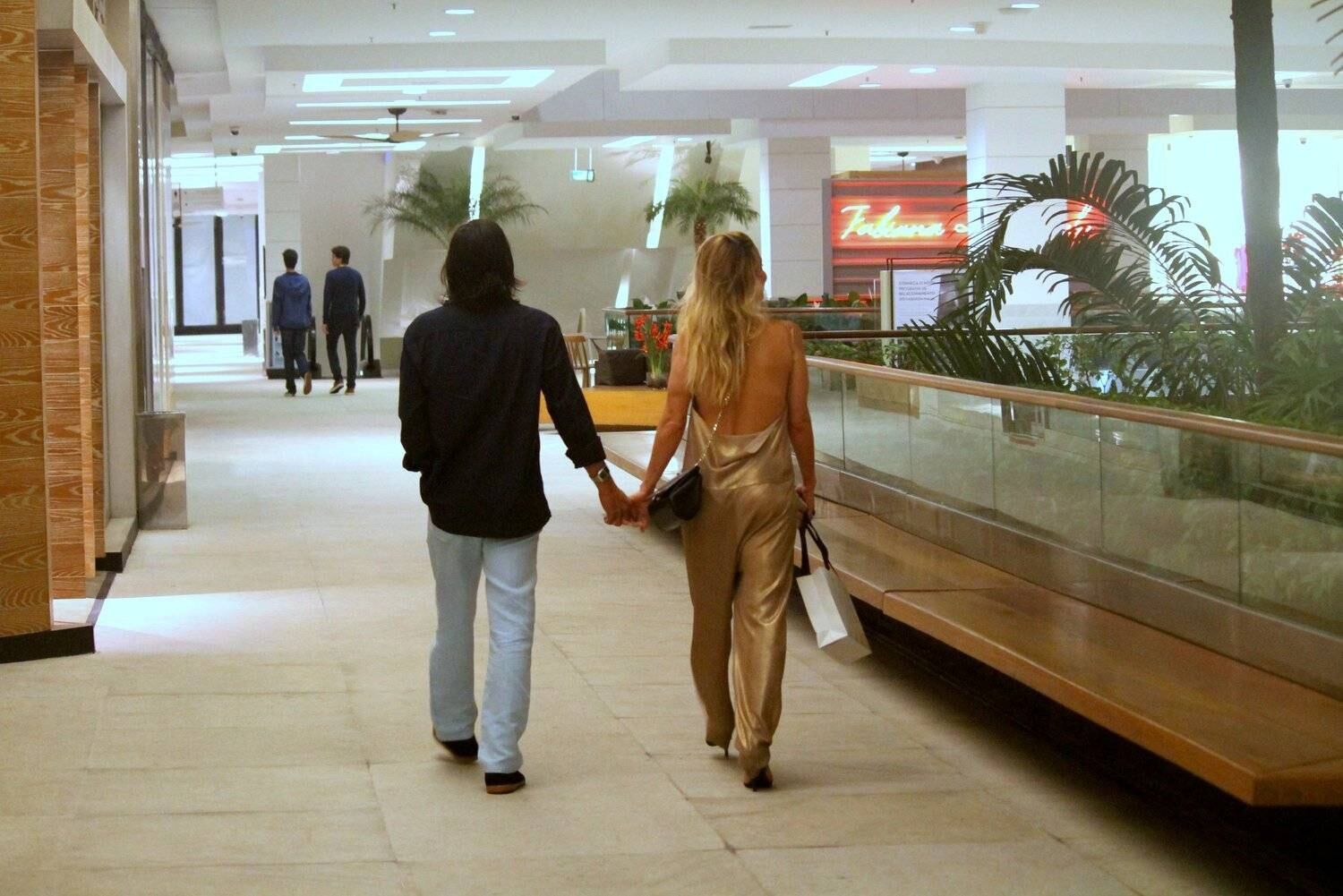 Danielle Winits e André Gonçalves passeiam de mãos dadas em shopping do Rio