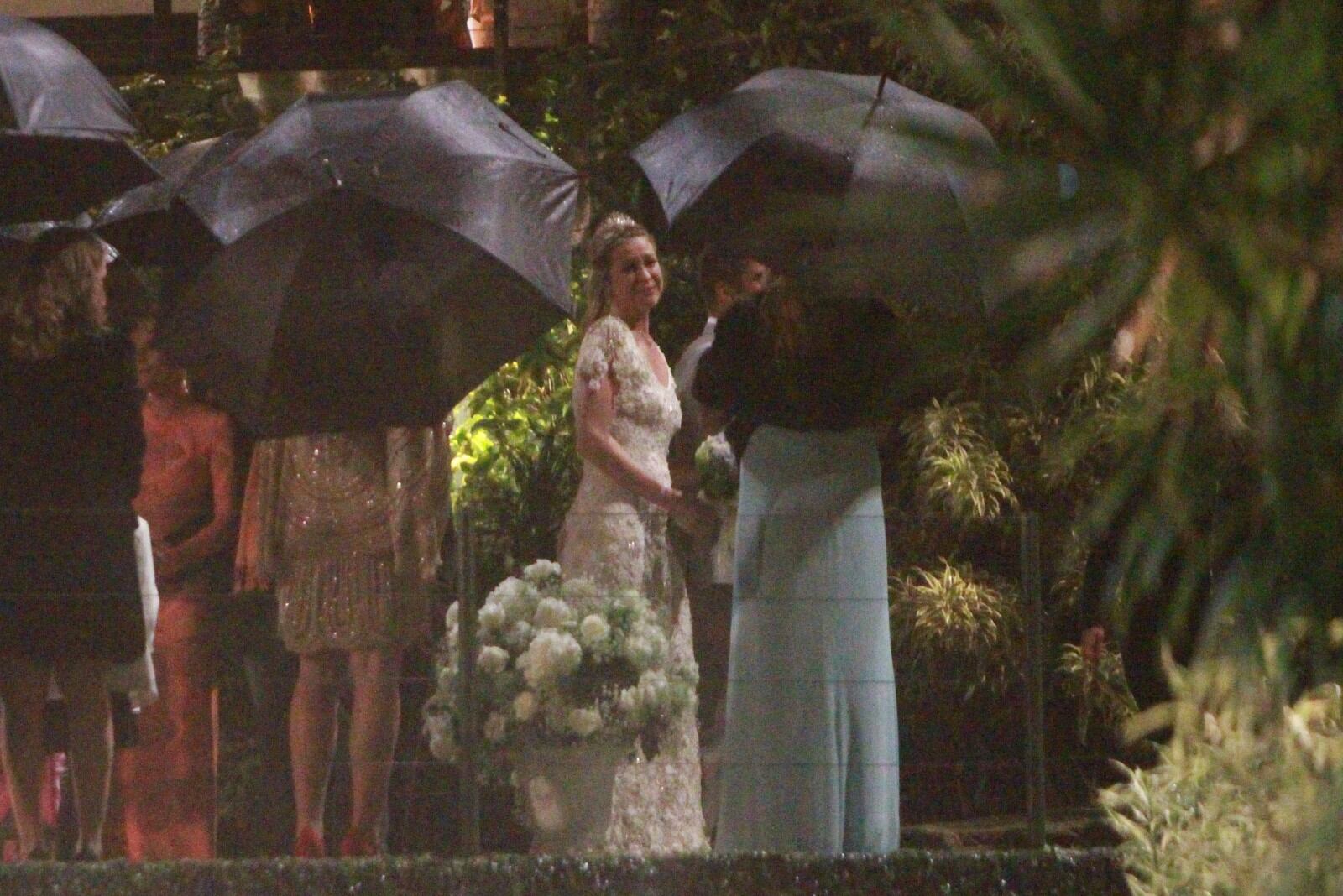 A atriz não pagou pelo toldo de cobertura do local da cerimônia, realizada num espaço ao ar livre. Olha todo mundo de guarda-chuva