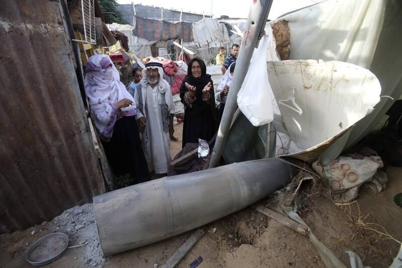 Mulher palestina gesticula
ao encontrar, em meio a escombros, míssil atirado por aeronaves israelense em Rafah, na Faixa de
Gaza