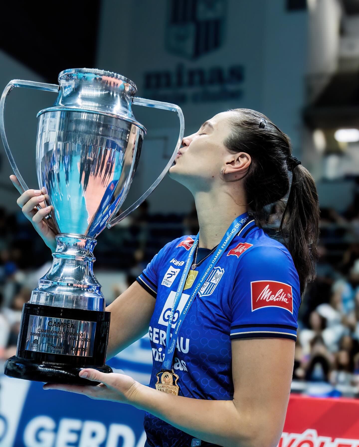 Júlia segurando o trófeu do Campeonato Mineiro de Voleibol Feminino