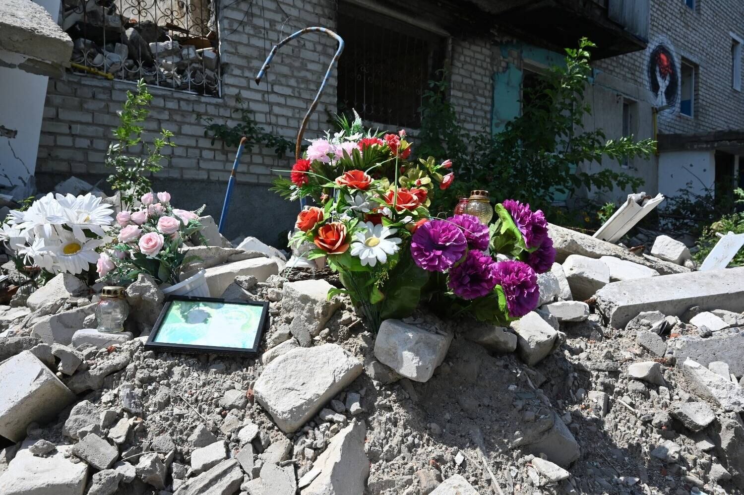 Imagem mostra flores expostas em um prédio residencial destruído em Izium, cidade no leste da Ucrânia