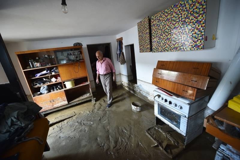 Em Krupanj, na Sérvia,
homem caminha por cômodo coberto de lama devido às inundações que atingem  o país