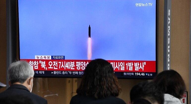 Pessoas assistem a uma televisão com imagens de arquivo de um teste de míssil norte-coreano