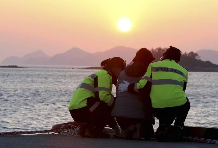Policiais confortam uma
familiar de um dos passageiros desaparecidos no naufrágio da balsa sul-coreana
enquanto ela espera por notícias das equipes de busca, no porto de Jindo, na
Coreia do Sul