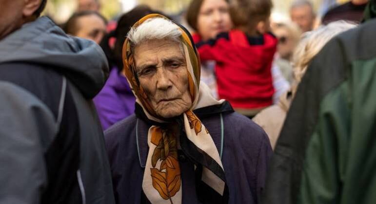 Idosa que saiu do leste da Ucrânia espera em fila para receber alimentos em Dnipro